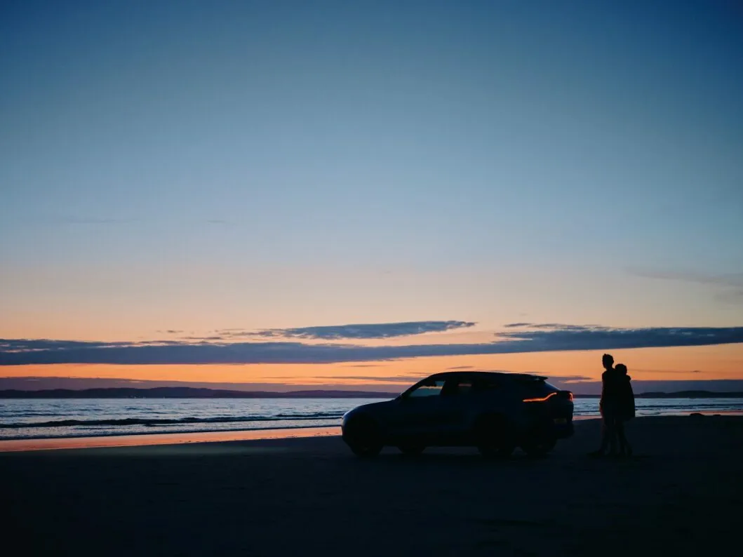 DBX and people on beach at sunset.