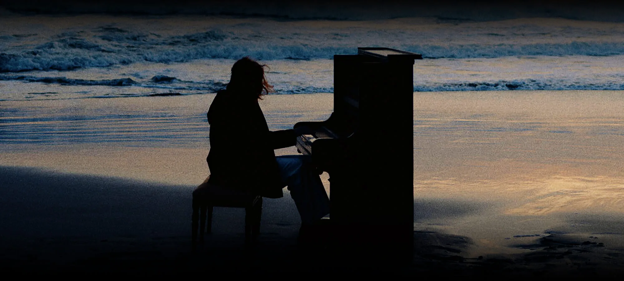 Woman playing piano on Islay beach.