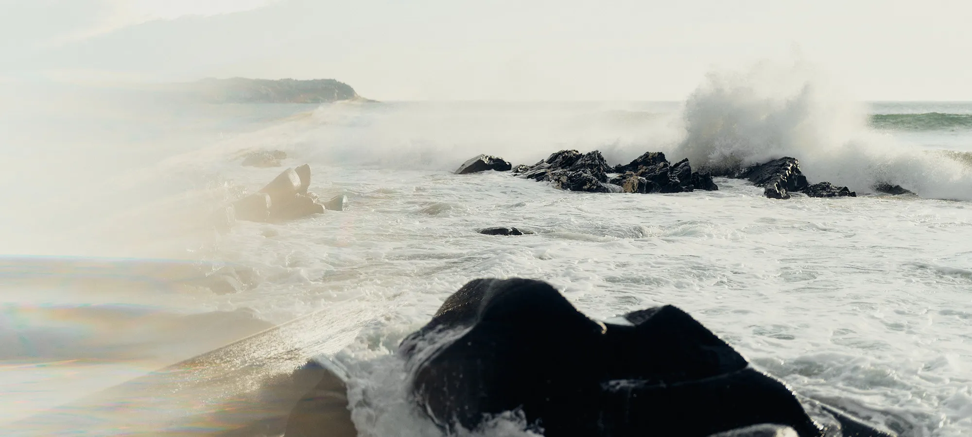 Wild white Islay sea and black rock